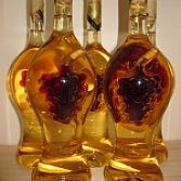 Elegant gevormde fles met een met rode wijn gevulde druiventros binnenin