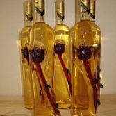 Fles in Bordeaux stijl met een met rode wijn gevulde gedraaide roos buitenop